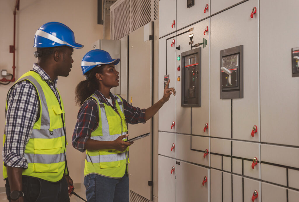 electrical engineer working in control room. electrical engineer man checking power distribution cabinet in the control room